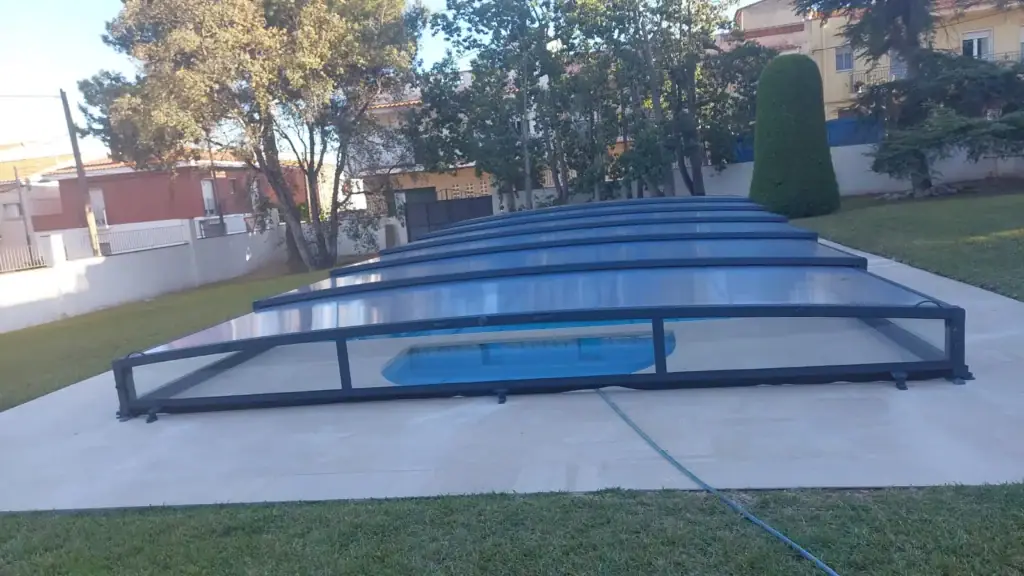 Piscina con la cubierta telescópica baja cerrada al atardecer