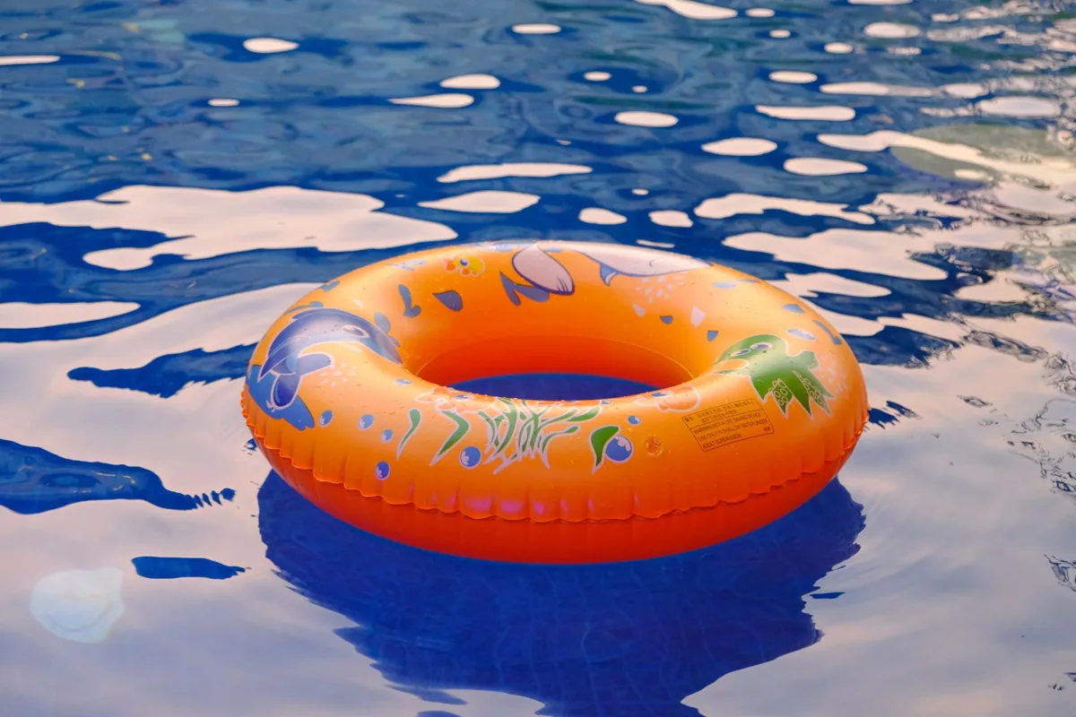 Flotador hinchable naranja flotando en el agua de una piscina