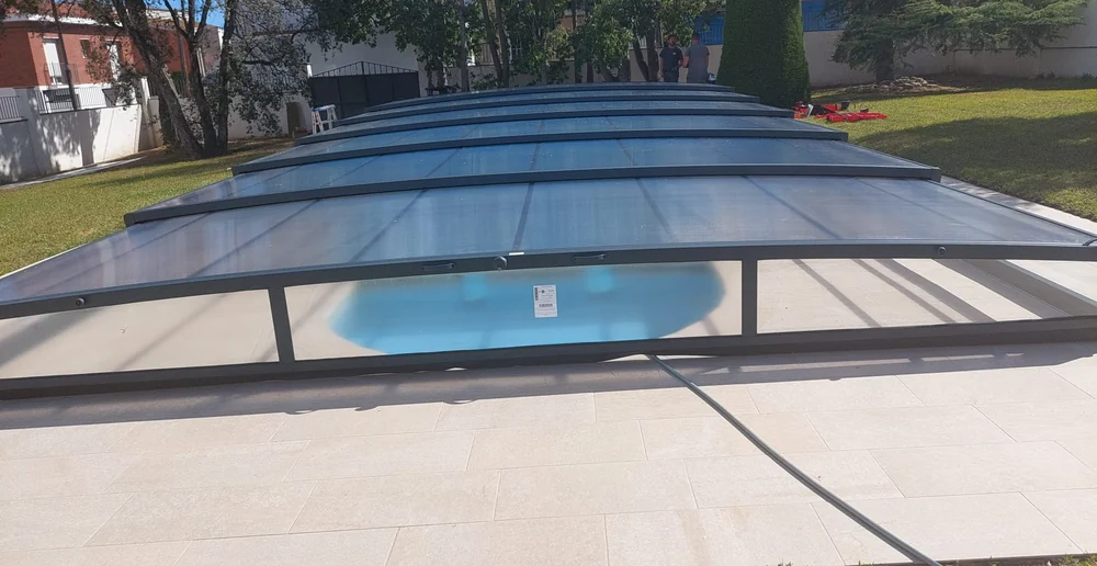 Módulos escalonados de una cubierta telescópica baja vistos en perspectiva desde la playa de la piscina