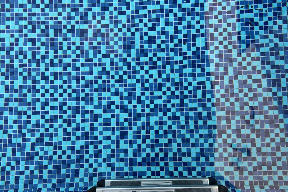Gresite de teselas azules de varios tonos en el vaso de una piscina