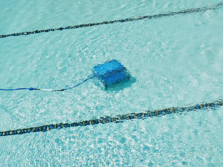 Robot limpiafondos trabajando en el fondo de una piscina